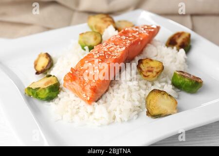 Filet de poisson servi avec du riz et des pousses de bruxelles sur plaque, à proximité Banque D'Images