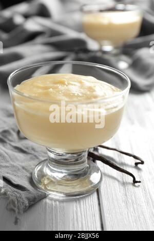 Pudding à la vanille dans un bol à dessert en verre sur une table en bois Banque D'Images