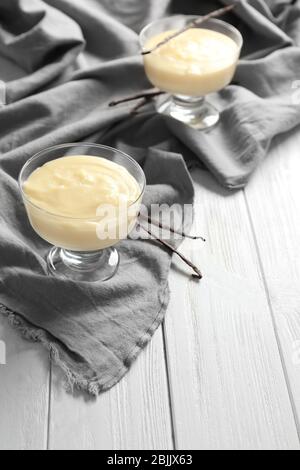 Pudding à la vanille dans des bols en verre à dessert sur tissu gris Banque D'Images