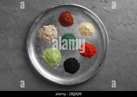 Différentes poudres supraalimentaires colorées sur plateau métallique Banque D'Images
