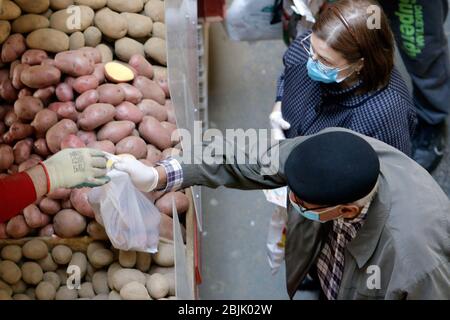 Bucarest, Roumanie. 29 avril 2020. Les personnes portant des masques achètent des pommes de terre sur un marché à Bucarest, en Roumanie, le 29 avril 2020. La Roumanie va lever le verrouillage national après le 15 mai, date à laquelle l'état d'urgence prendra fin, a annoncé récemment le président Klaus Iohannis. Crédit: Cristian Cristel/Xinhua/Alay Live News Banque D'Images