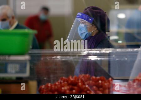 Bucarest, Roumanie. 29 avril 2020. Une femme portant un masque de visage marche sur un marché à Bucarest, Roumanie, le 29 avril 2020. La Roumanie va lever le verrouillage national après le 15 mai, date à laquelle l'état d'urgence prendra fin, a annoncé récemment le président Klaus Iohannis. Crédit: Cristian Cristel/Xinhua/Alay Live News Banque D'Images