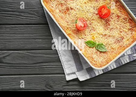 Plaque de cuisson avec de savoureux lasagnes aux épinards sur table en bois Banque D'Images