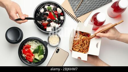 Les gens mangent à emporter. Livraison de nourriture. Des plats savoureux sur une table blanche Banque D'Images