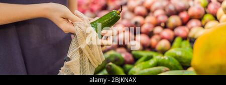 Femme choisit l'avocat dans un supermarché sans utiliser de sac en plastique. Sac réutilisable pour acheter des légumes. BANNIÈRE concept zéro déchet, FORMAT LONG Banque D'Images