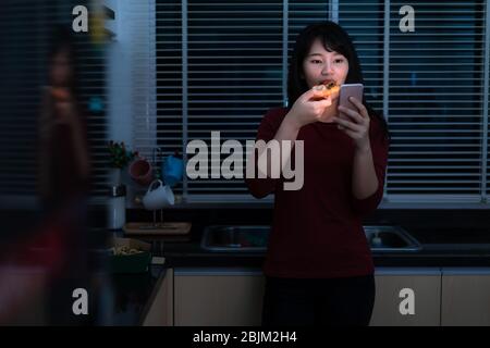 Femme asiatique virtuelle Happy Hour réunion et manger la livraison de pizza de la boîte en ligne avec ami ou prendre des photos à l'aide de l'appareil photo de téléphone mobile dans la cuisine Banque D'Images