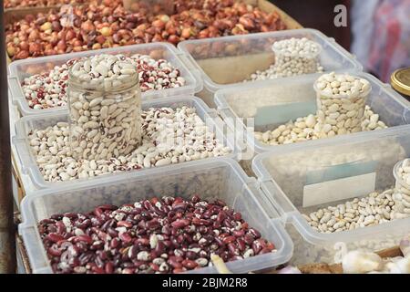 Assortiment de haricots dans des récipients en plastique sur le marché Banque D'Images
