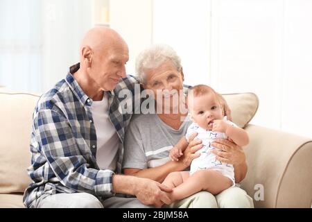 Couple senior avec leur petit-enfant se reposant à la maison Banque D'Images