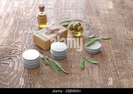 Pots avec crème et savon avec extrait d'olive sur fond en bois Banque D'Images