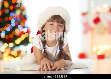 Jolie petite fille à Santa Hat à la maison Banque D'Images