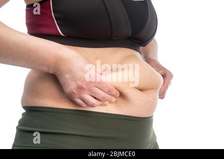 Femme avec des plis de graisse sur son estomac. Image conceptuelle de l'obésité. Vue latérale. Gros plan, isolé sur un fond blanc. Banque D'Images
