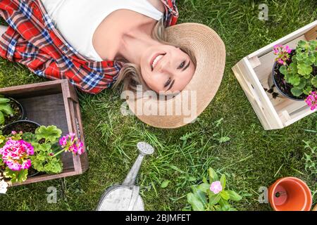 Belle jeune femme posée sur l'herbe dans le jardin