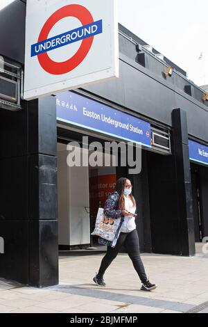 Une femme masquée quitte la station de métro Euston calme de Londres jeudi 30 avril 2020, comme rapport du Groupe de coordination stratégique de Londres Banque D'Images