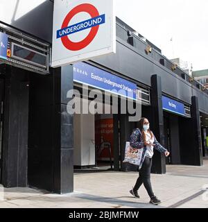 Une femme masquée quitte la station de métro Euston calme de Londres jeudi 30 avril 2020, comme rapport du Groupe de coordination stratégique de Londres Banque D'Images