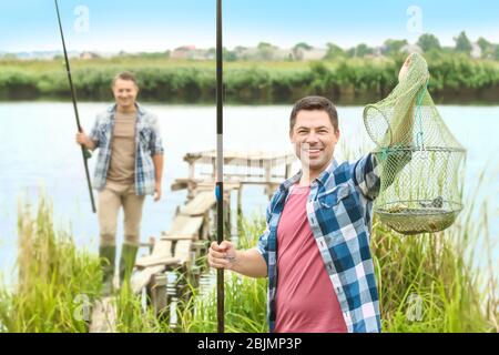 Deux pêcheurs avec du poisson fraîchement pêché sur la jetée Banque D'Images