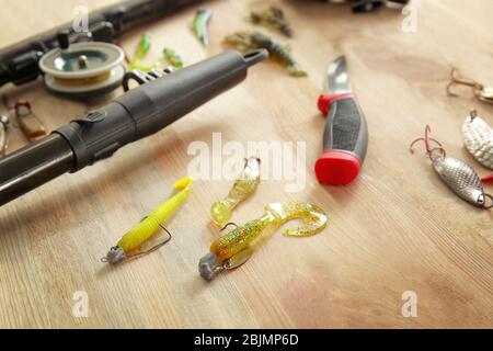 Appâts à cuillère et baguette de pêche sur table en bois Banque D'Images