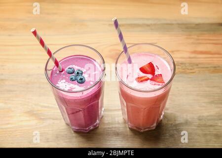 Verres avec smoothie yummy sur table en bois Banque D'Images