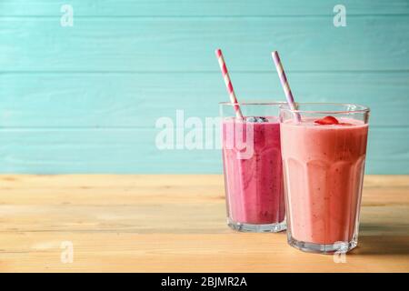 Verres avec smoothie yummy sur table en bois Banque D'Images