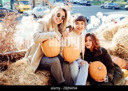 Les filles tient les citrouilles dans les mains sur le fond de la rue. Banque D'Images