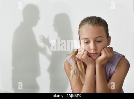 Petite fille et silhouettes de parents en querelant sur le fond. Concept de violence familiale Banque D'Images