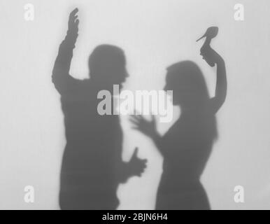 Silhouettes de l'homme et de la femme en querelles sur fond blanc. Concept de violence familiale Banque D'Images
