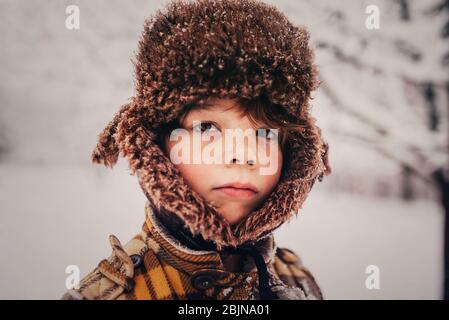 Portrait d'un garçon portant une casquette de chasseur dans la neige, États-Unis Banque D'Images