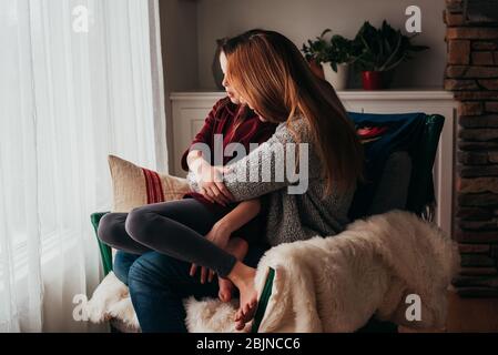 Mère et fille se couchant dans un fauteuil Banque D'Images