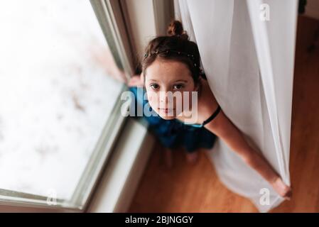 Vue de dessus d'une fille debout près d'une fenêtre Banque D'Images