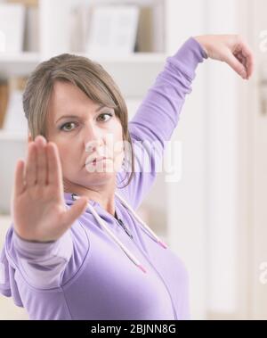 Belle femme faisant de l'exercice de tai chi qi gong à la maison Banque D'Images