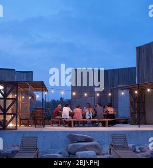 Dîner dehors à l'heure du dîner dans la cour commune. Casa Naila, Puerto Escondido, Mexique. Architecte: BAAQ, 2020. Banque D'Images