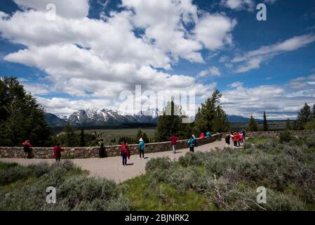 Le parc national du Grand Teton, situé sur la rivière Snake, surplombe le point d'observation, où les touristes portent des vêtements colorés et prennent des photos Banque D'Images