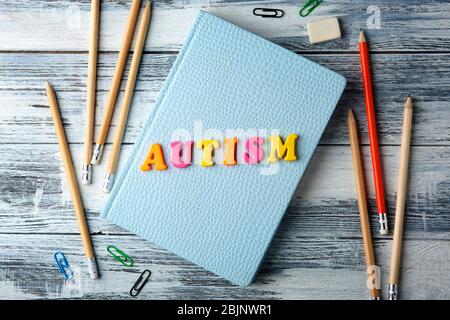 Mot AUTISME fait de lettres et bloc-notes sur fond de bois Banque D'Images