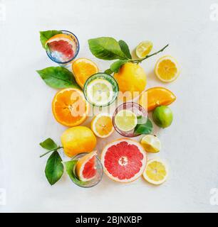 Composition de groupe de divers agrumes biologiques avec feuilles vertes sur fond blanc, vue de dessus. Une nourriture saine. Ingrédients. Vitamine. Moitiés et sl Banque D'Images