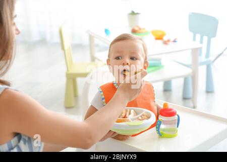 Femme qui allaite son bébé à la maison Banque D'Images