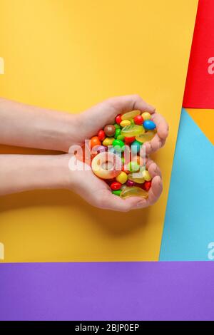 Femme tenant des bonbons colorés sur fond de couleur Banque D'Images