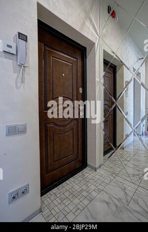 Nouvelle porte en bois. Vue sur le hall intérieur. Intérieur lumineux d'une belle salle moderne dans le style du minimalisme avec des murs blancs, une belle chande Banque D'Images
