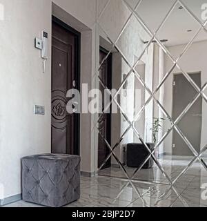Vue sur le hall intérieur. Intérieur lumineux d'une belle salle moderne dans le style du minimalisme avec des murs blancs, un beau lustre, un grand mir Banque D'Images