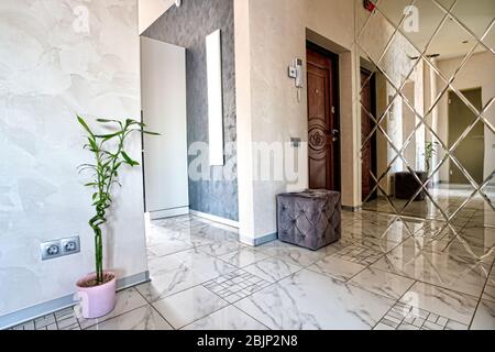 Vue sur le hall intérieur. Intérieur lumineux d'une belle salle moderne dans le style du minimalisme avec des murs blancs, un beau lustre, un grand mir Banque D'Images