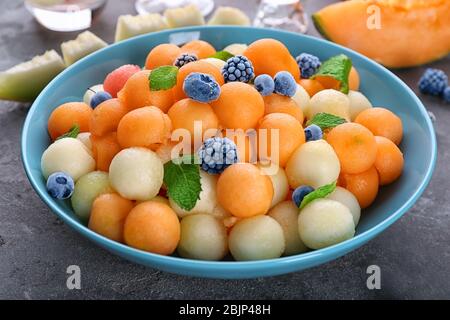 Assiette avec des boules de fruits frais sur la table Banque D'Images