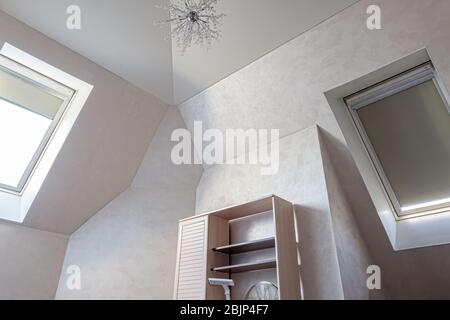 Plafond à plâtrement clair et multiniveaux dans une chambre mansardée moderne avec une fenêtre Dormer Banque D'Images