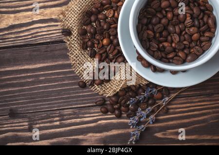 Tasse à café avec grains de café et branches de lavande sur un plan d'examen en bois. Vue de dessus Banque D'Images