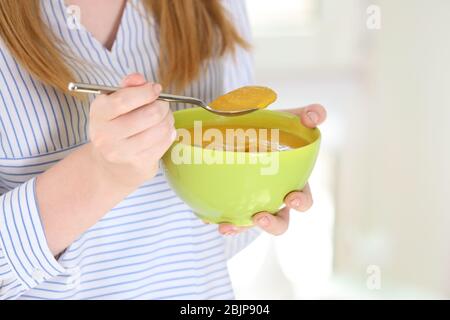 Femme tenant bol et cuillère avec soupe de crème de lentilles maison Banque D'Images