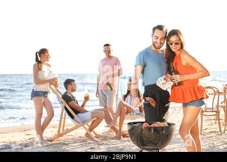 Les jeunes ont une fête barbecue sur la plage Banque D'Images
