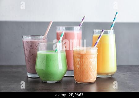 Différents milkshakes aux fruits en verre sur la table Banque D'Images