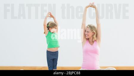 Les mots Flatten the Curve avec une femme et une fille caucasiennes pratiquant le yoga pendant le coronavirus Covid19 Banque D'Images