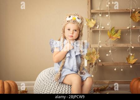 Adorable petite fille dans un chapeau tricoté à l'intérieur Banque D'Images