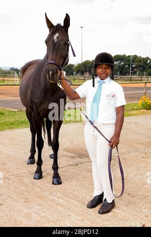 Soweto, Afrique du Sud - 16 avril 2012: Jeune garçon africain tenant les rênes d'un cheval Banque D'Images