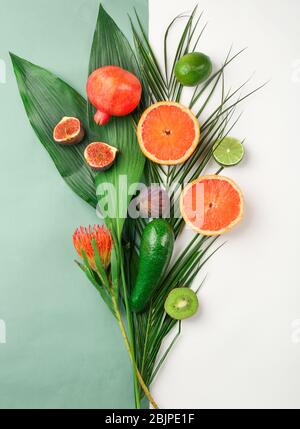 Composition avec feuilles tropicales et fruits exotiques sur fond blanc Banque D'Images