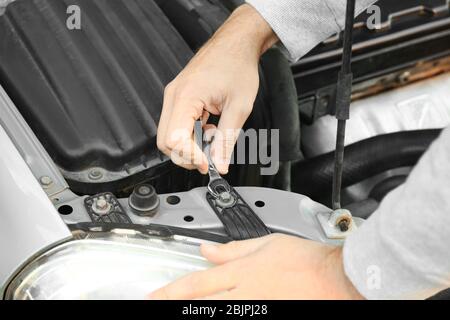 Jeune homme mécanicien réparation de voiture, clôture Banque D'Images