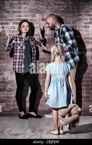 Petite fille et les parents de disputer contre le mur de briques Banque D'Images